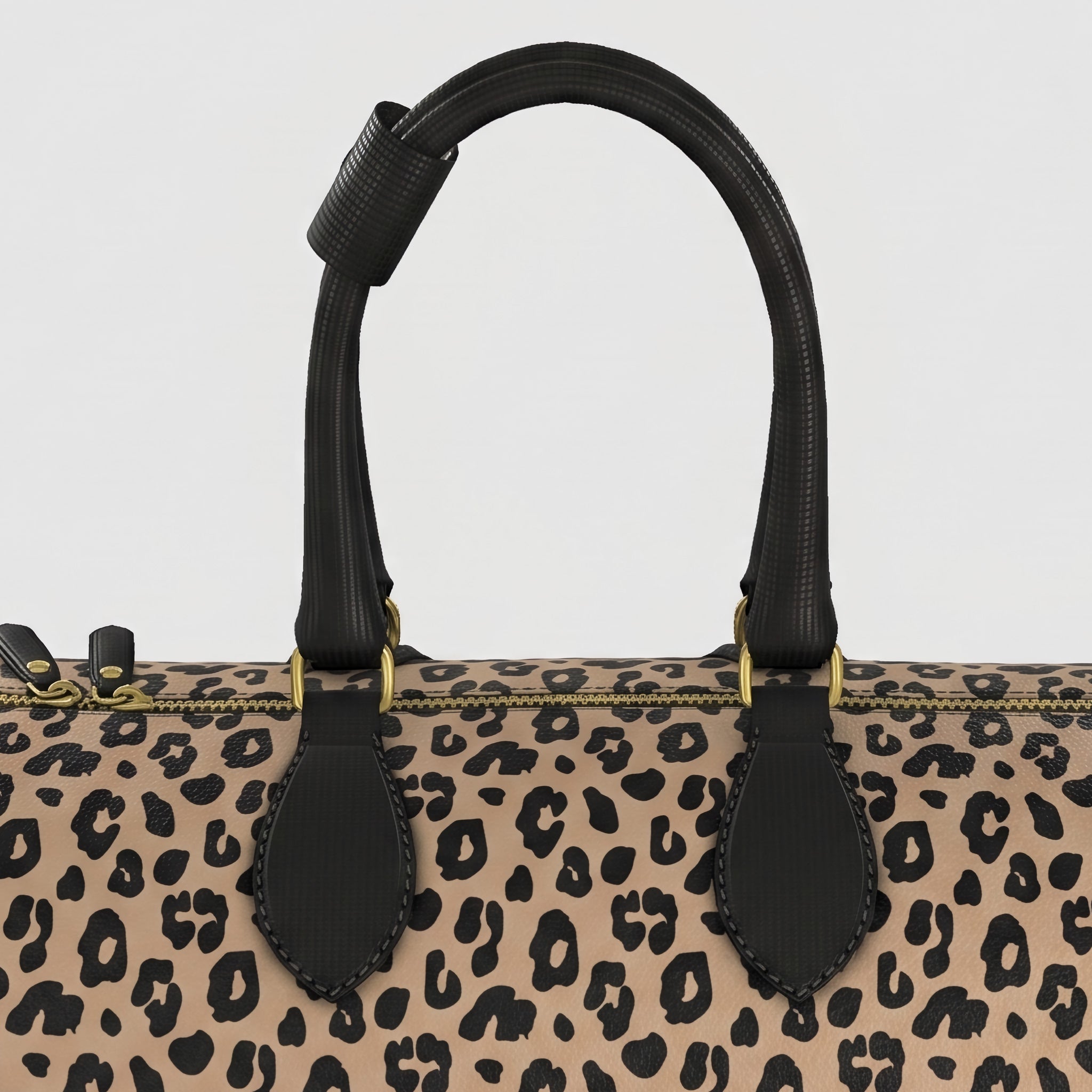 Close-up of a large Sahara leopard-print handbag with black leather handles and gold-tone hardware against a light gray background.